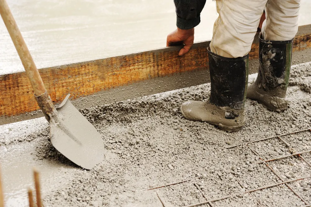 Finisher working the surface of a freshly poured concrete slab
